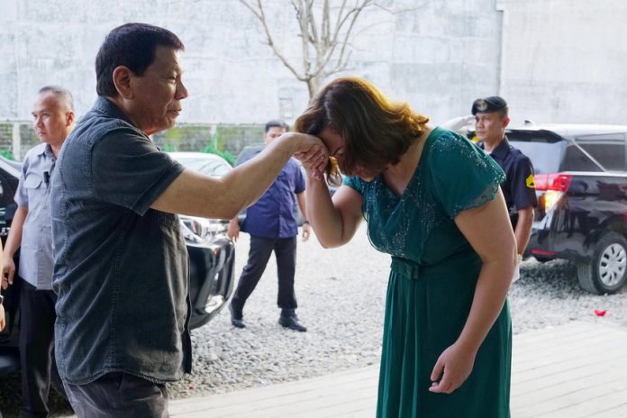 TIME-OLD TRADITION. President Rodrigo Duterte extends his hand to his daughter Davao City Mayor Sara Duterte-Carpio who showed a gesture of respect upon her father's arrival at the Azuela Cove in Lanang, Davao City for his attendance to the 7th Lesbian, Gay, Bisexual and Transgender (LGBT) Davao Year-End Gathering on Sunday night. PRESIDENTIAL PHOTO