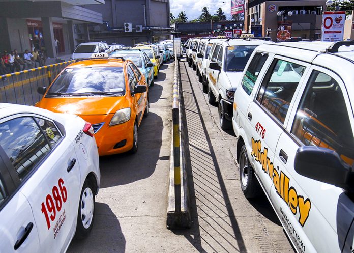 UPGRADING. Taxi units form a long queue as the drivers wait for passengers outside a shopping mall along J.P. Laurel Ave., Davao City on Wednesday. The Metro Davao Taxi Operators Association, Inc. (MEDTOA) has started to install cellular phone units to taxi units for use in the implementation of the Hirna taxi hailing app project which is scheduled to be launched next month. LEAN DAVAL JR