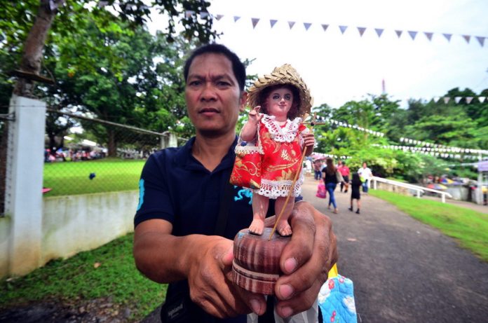 STO. NINO IMAGE. A devotee shows his miniature Sto. Nino image after it was blessed during the Golden Jubilee of the Shrine of the Holy Infant Jesus of Prague in Shrine Hills, Matina, Davao City on Monday. LEAN DAVAL JR.