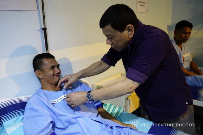 DESERVING. President RodrigoDuterte confers the Order of Lapu-Lapu Kampilan Medal on CAFGU Active Auxiliary Jimmy Gonzaga during his visit to the wounded soldiers at Camp Panacan Station Hospital at the Naval Station Felix Apolinario in Davao City on Monday night. Gonzaga was wounded in an encounter with members of the New People's Army in Makilala, Cotabato recently. PRESIDENTIAL PHOTO