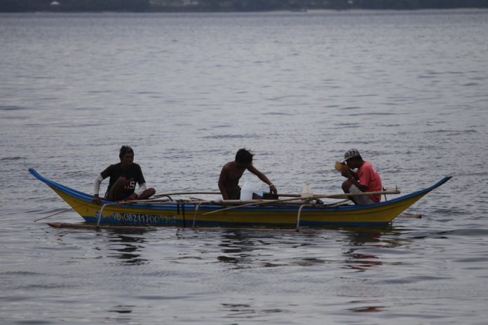 A group of fishermen spends their afternoon drinking coconut wine locally known as “tuba” after a day of fishing at the beachfront near Sta. Ana Wharf in Davao City on Thursday. LEAN DAVAL JR.