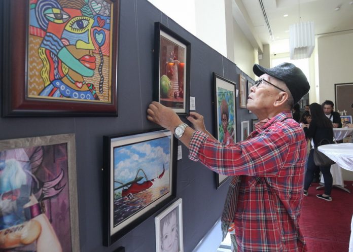 THE OTHER RBL. Veteran photojournalist Rene Lumawag makes a last minute adjustment of his art work, an acrylic on canvas entitled ‘Still Life,’ before the opening of an art exhibit of 25 artists from the Davao Artist group at the lobby of Park Inn by Radisson Davao on Tuesday. The art exhibit is for the benefit of Badjao children from the rainbow community in Matina Aplaya. LEAN DAVAL JR