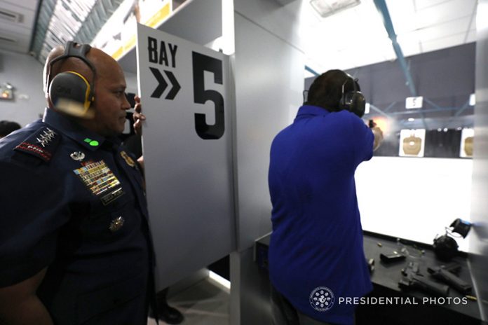 GUN-HANDY. President Rodrigo Duterte fires a few rounds from the .45, .40 and 9mm caliber pistols as he leads the ceremonial shoot during the inauguration of the Armscor Shooting Range Davao Branch in Davao City on Monday. Also in the photo is Philippine National Police Director General Ronald dela Rosa. PRESIDENTIAL PHOTO