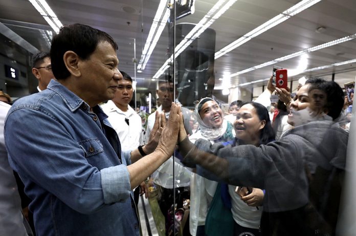 GETTING FIRST-HAND. President Rodrigo Duterte interacts with Overseas Filipino Workers (OFW) who availed themselves of amnesty from Kuwait after welcoming them home at the Ninoy Aquino International Airport in Pasay City on Monday evening. PRESIDENTIAL PHOTO