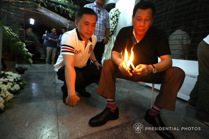 IN MEMORY. President Rodrigo Duterte is accompanied by Special Assistant to the President Christopher Lawrence Go as he lights a candle to commemorate the death anniversary of his mother Soledad 'Nanay Soling' Duterte at the Roman Catholic Public Cemetery in Davao City on Sunday night. PRESIDENTIAL PHOTO