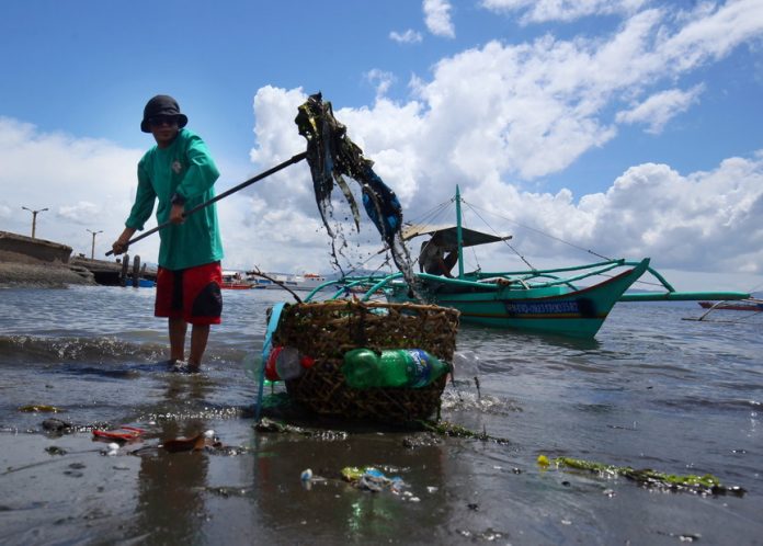 CLEAN-UP. A Bantay Dagat team member from Brgy. 27-C Leon Garcia in Davao City collects the trash along the beachfront near Sta. Ana Port on Saturday. Brgy. 27-C’s Bantay Dagat team conducts coastal clean up every Saturday to help get rid of the garbage on the barangay’s beachfronts. LEAN DAVAL JR