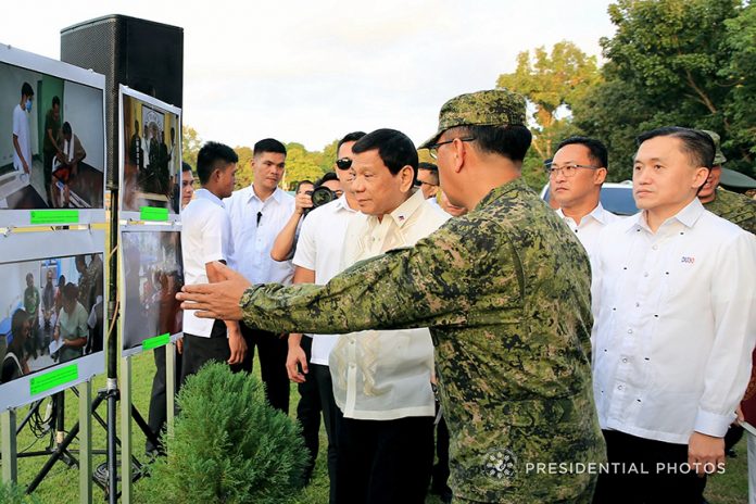 GROUND UPDATE. President Rodrigo Duterte is given a briefing by Western Mindanao Command (WestMinCom) Commander Lieutenant General Carlito Galvez Jr. on the various accomplishments of their unit during the President's visit to troops at the Edwin Andrews Air Base in Sta. Maria, Zamboanga City on Friday. Also in the photo is Special Assistant to the President Christopher Lawrence Go. PRESIDENTIAL PHOTO