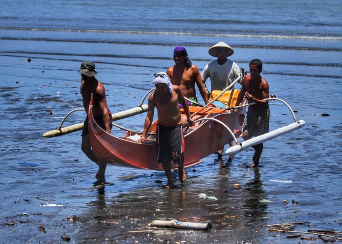 DONE FOR THE DAY. A group of fishermen from Brgy 76-A Bucana carries to shore a boat after a night of fishing at the Davao Gulf on Saturday. The City Agriculturist Office will conduct an Agribiz Expo for agri fishery based sector as part of the Araw ng Davao 2018 activities at Abreeza mall which aims to help the local fisherfolk learn new ideas and methods. LEAN DAVAL JR