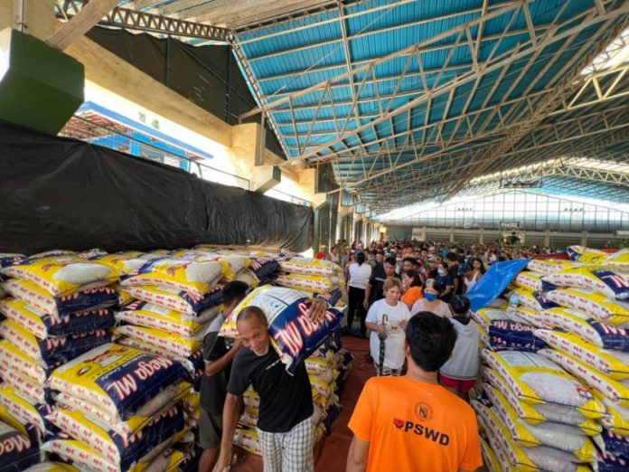 A resident carries a sack of rice from a storage house in Carrascal, Surigao del Sur. Photo courtesy of Mayor VJ Hotchkiss Pimentel Facebook page