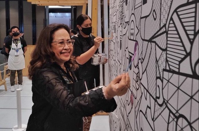 Davao City Chamber of Commerce and Industry, Inc. (DCCCII) president Dr. Maria Lourdes Monteverde and Department of Tourism 11 (DOT 11) director Tanya Rabat-Tan try their creativity on the color stories wall of one of the booths during the opening of PhilConstruct 2022 exhibit at SMX Convention Center in Davao City on Thursday. Edge Davao