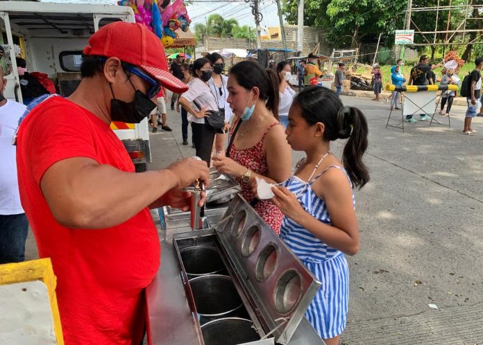 A vendor takes advantage of the high foot traffic and the warm weather to sell ice cream during All Souls' Day celebration at Wireless Cemetery in Father Selga Street, Davao City on Wednesday. Edge Davao