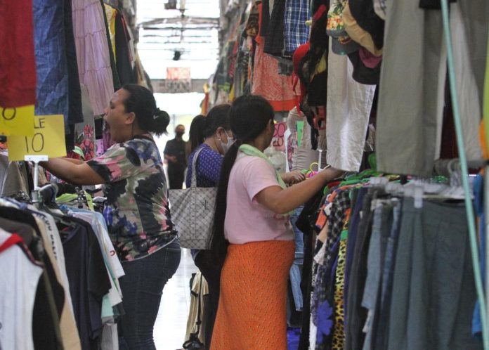 Customers browse the wide collection of used ready-to-wear clothes at an 