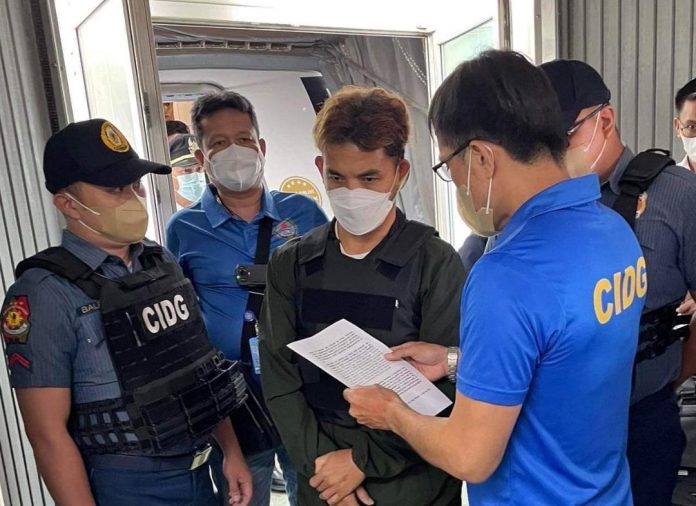 Suspected top-ranking New People's Army (NPA) leader Eric John Casilao is being read with his warrant of arrest upon arrival at the Davao International Airport from Manila on Monday. Contributed photo