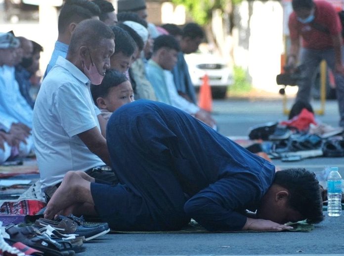 A Muslim prays in sujud during a morning prayer in celebration of Eid'l Fitr or end of Ramadan along Roxas Avenue in Davao City on Saturday. LEAN DAVAL JR.