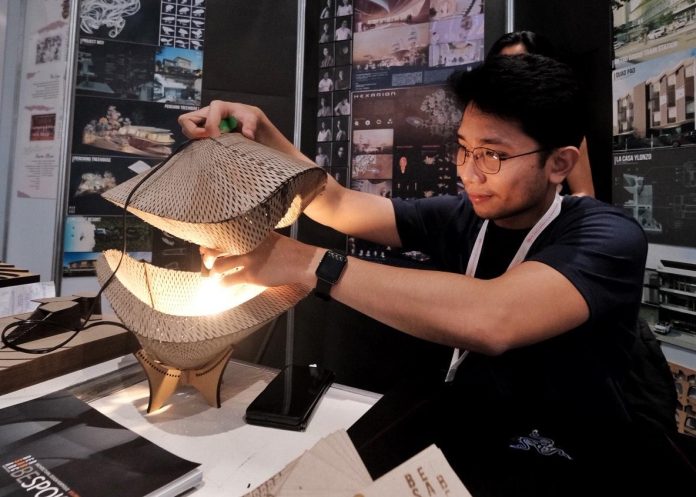 An exhibitor shows an innovative designed table lamp made from locally sourced materials at a booth where new designs and innovation are being showcased during the third day of PHILBEX and TLEX Davao 2023 at SMX Convention Center in Davao City on Saturday. LEAN DAVAL JR.