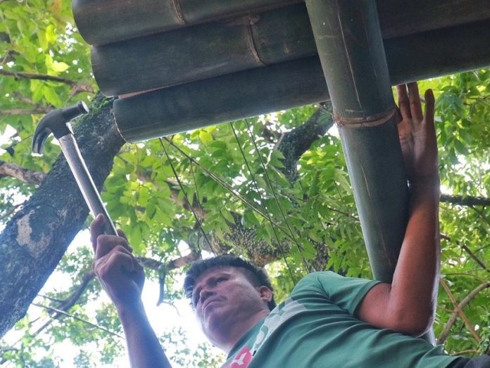 A man repairs the front portion of the Kagan tribe's traditional house at the Kadayawan village inside Magsaysay Park in Davao City on Friday. The Kadayawan village is slated to open on August 7. LEAN DAVAL JR.