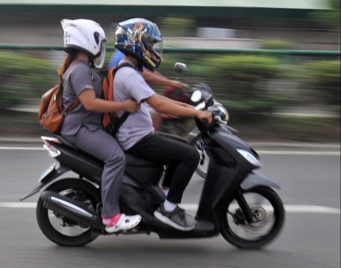 A motorcycle rider with a pillion passenger traverse along Brgy. Sasa, Davao City on Thursday. Davao City Councilor Conrado Baluran, chair of the committee on transportation and communication, believes the operation of motor taxis could help prevent crimes in Davao City. LEAN DAVAL JR.