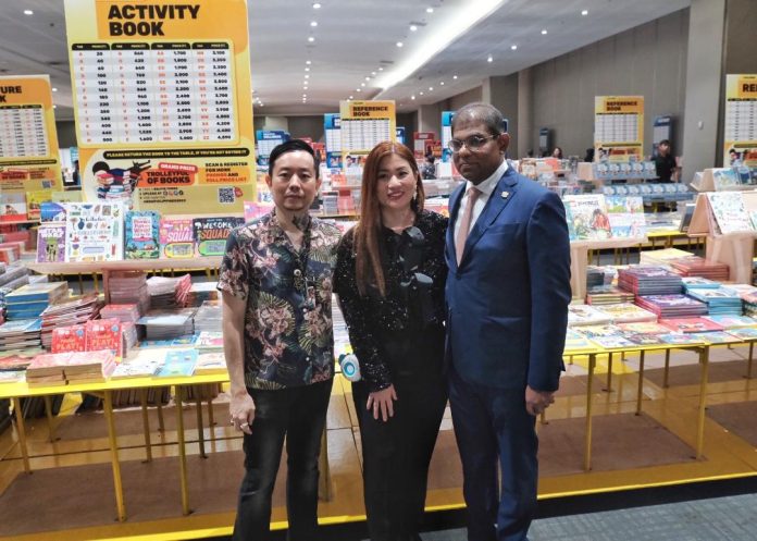 Big Bad Wolf co-founder Andrew Yap, local partner Carol Chuaying and guest of honor His Excellency, Abdul Malik Melvin Castelino, Ambassador of Malaysia to the Philippines, pose for photos in front of the wide collection of books during the opening of Big Bad Wolf Davao 2023 at SMX Convention Center in Davao City on Thursday. LEAN DAVAL JR