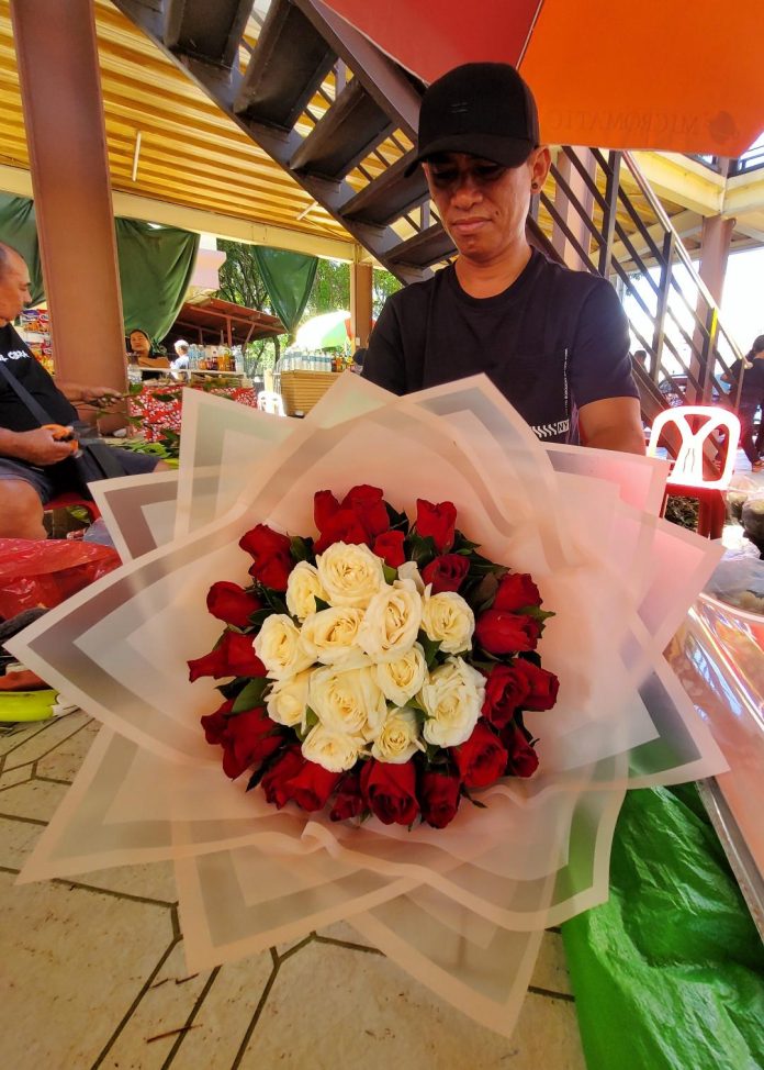 A florist arranges a bouquet of roses at the San Pedro Flower Bouquets Market along San Pedro Street in Davao City a day before Valentine's Day. LEAN DAVAL JR