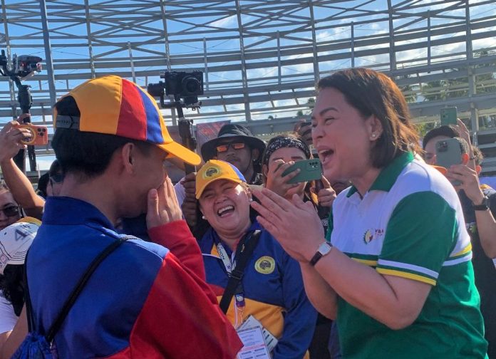 Vice President and Education Secretary Sara Duterte bursts out in laughter while chatting with one of the athletes from Davao Occidental during the opening of Davao Regional Athletics Association (DAVRAA) Meet held at Davao City-UP Sports Complex in Mintal, Davao City on Monday. LEAN DAVAL JR