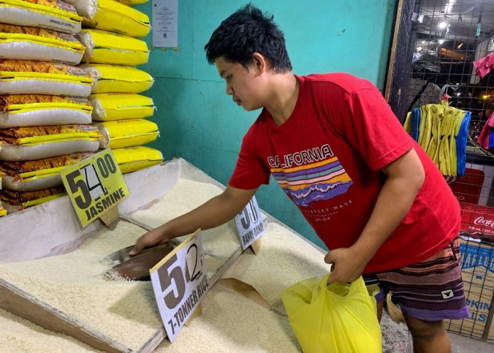 A store worker prepares commercial rice for a customer at a community market in Davao City on Monday. The country is expected to remain the world’s biggest importer of rice next year, according to the data released by the United States Department of Agriculture (USDA). LEAN DAVAL JR