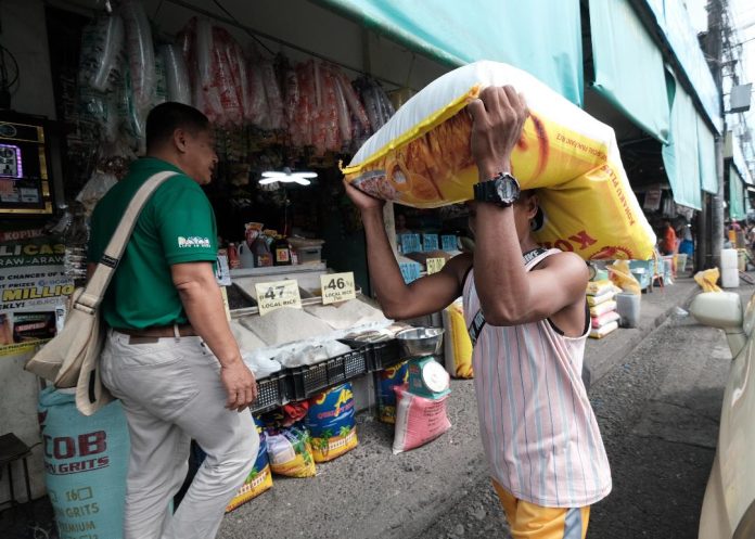 A porter delivers a sack of commercial rice at Bankerohan Public Market in Davao City. The Department of Agriculture (DA) is determined to achieve its unmilled rice or palay production target this year despite the impact of El Niño on the local rice sector. LEAN DAVAL JR