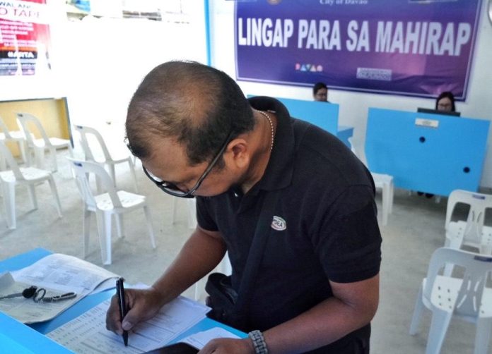 A man, who is the first client of Lingap Para sa Mahirap Poblacion satellite office inside the Davao City Recreation Center compound along Quimpo Blvd. in Davao City, fills up a form for an assistance application on Thursday. The Lingap Poblacion is the city goverment of Davao's 6th Lingap Para sa Mahirap satellite office in the city. LEAN DAVAL JR