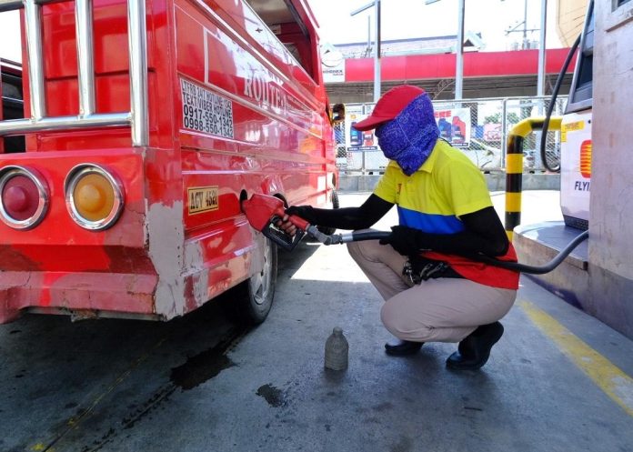 A pump attendant refills a public utility vehicle (PUV) with gasoline at a station along C. Bangoy Street in Davao City on Monday. Oil companies announced that diesel and kerosene prices will go up while gasoline prices will drop starting Tuesday. LEAN DAVAL JR