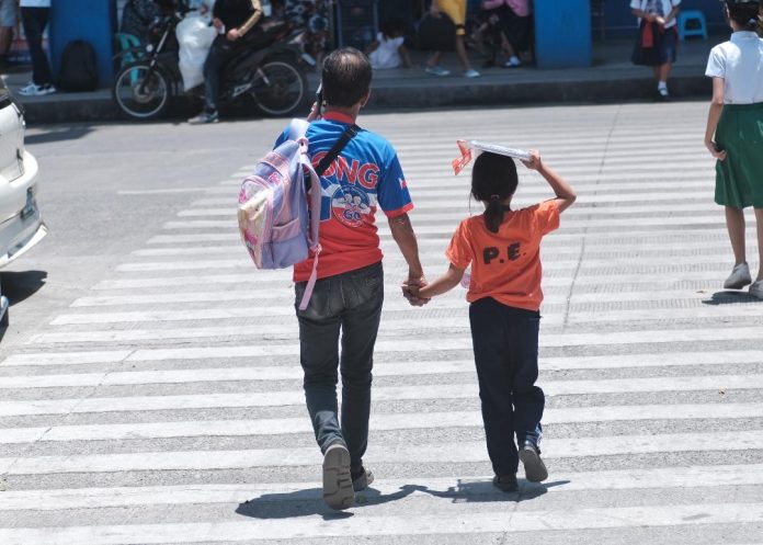 A father, together with his daughter, crosses the usually busy San Pedro Street after fetching the latter from school in Davao City. The City Council of Davao has passed the Solo Parents’ Ordinance of Davao City on Tuesday. The Implementing Rules and Regulations (IRR) that will ensure the effective implementation of the said ordinance was already issued by the city government of Davao last month. LEAN DAVAL JR