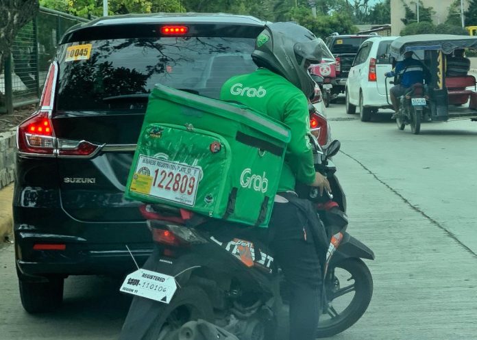 A delivery rider maneuvers through a congested street in Davao City. Delivery riders in the city is step closer to be exempt from business permit requirement after an amendment to the ordinance that will no longer require them to obtain a business permit was passed on the second reading by the City Council on Tuesday. LEAN DAVAL JR