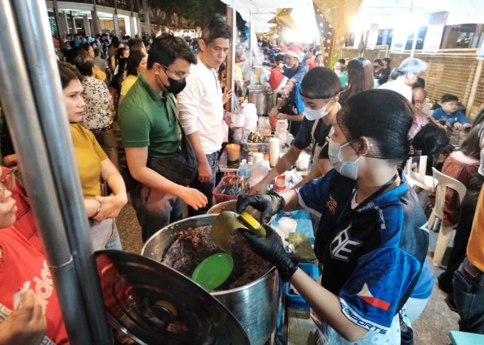 Church goers gather at a stall selling puto maya and sikwate (hot chocolate) at the 