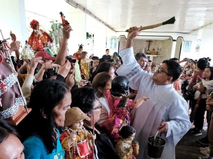 Sto. Niño images are sprinkled with holy water by a Catholic priest during the 57th Patronal Fiesta of the Shrine of the Holy Infant of Jesus of Prague in Shrine Hills, Matina, Davao City on Wednesday. LEAN DAVAL JR